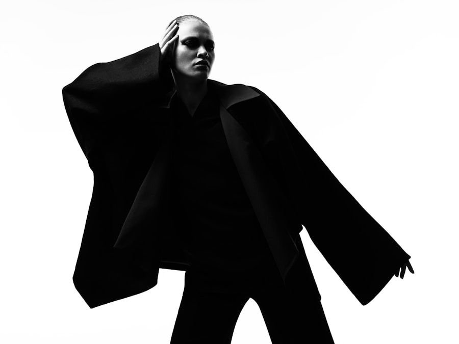 Sculptural black coat photographed as a silhouette against a plain white ground